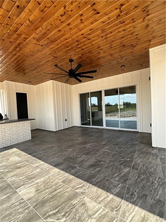 unfurnished living room with ceiling fan and wood ceiling