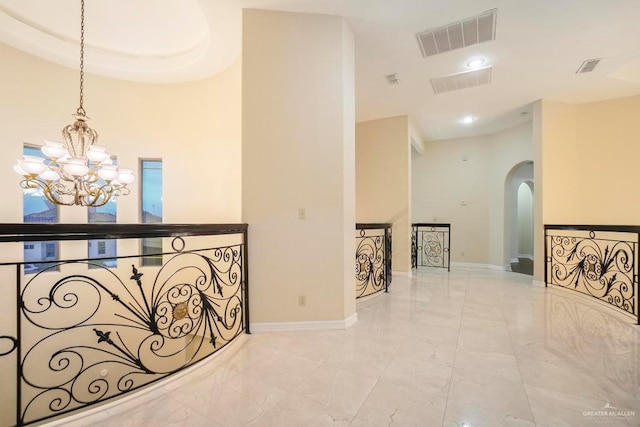 2806 S Woods Dr, Edinburg, TX 78542 - hallway with a notable chandelier, marble finish floor, baseboards, visible vents, and arched walkways