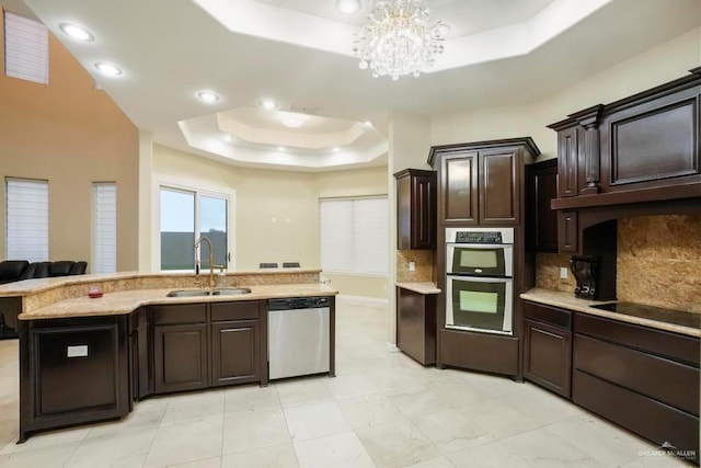 2806 S Woods Dr, Edinburg, TX 78542 - kitchen with a tray ceiling, a sink, a chandelier, appliances with stainless steel finishes, and decorative backsplash