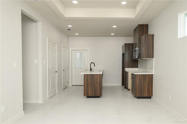 613 Cove Ln Unit 2, Weslaco, TX 78596 - kitchen featuring stainless steel microwave, light countertops, baseboards, recessed lighting, and a center island with sink