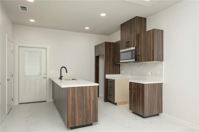 613 Cove Ln Unit 2, Weslaco, TX 78596 - kitchen with stainless steel microwave, a sink, modern cabinets, recessed lighting, and light countertops