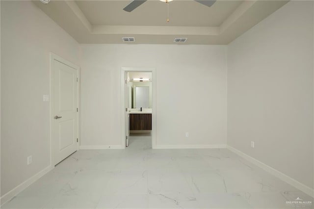 613 Cove Ln Unit 2, Weslaco, TX 78596 - spare room with a tray ceiling, light marble finish flooring, a ceiling fan, and baseboards