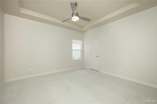 613 Cove Ln Unit 2, Weslaco, TX 78596 - unfurnished room with a tray ceiling, light marble finish floors, and baseboards