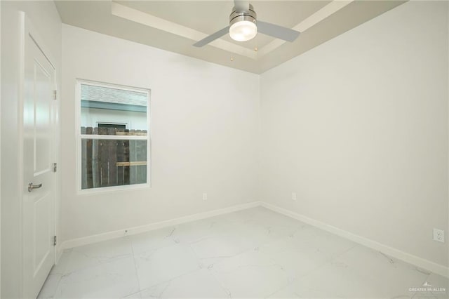 613 Cove Ln Unit 2, Weslaco, TX 78596 - empty room featuring baseboards, light marble finish flooring, ceiling fan, and a tray ceiling