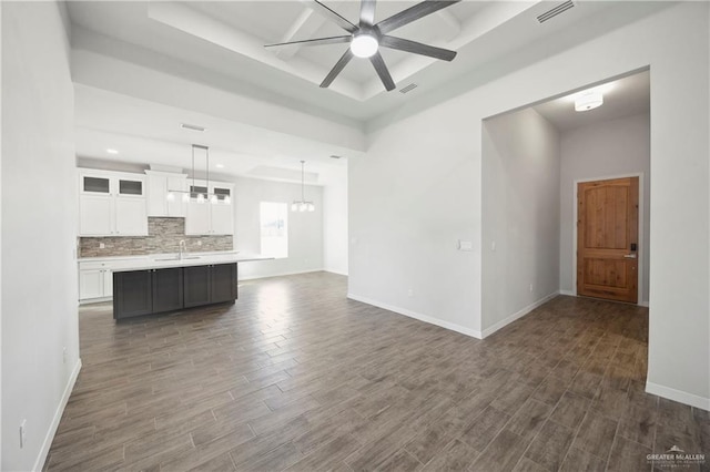 unfurnished living room featuring ceiling fan, sink, and dark wood-type flooring