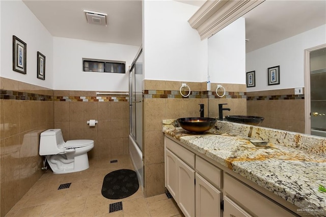 bathroom featuring visible vents, tile walls, tile patterned floors, vanity, and toilet