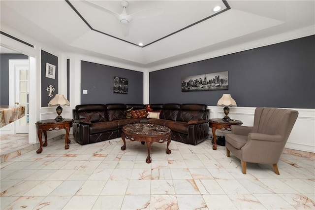 living room featuring a decorative wall, a tray ceiling, recessed lighting, and marble finish floor