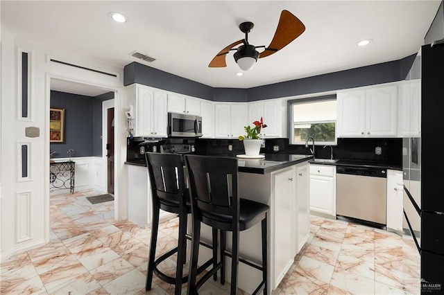 kitchen with visible vents, marble finish floor, dark countertops, and stainless steel appliances