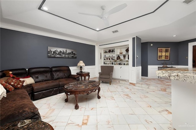 living room featuring built in features, a decorative wall, recessed lighting, and visible vents