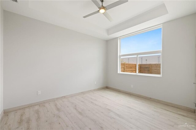 1220 N Lincoln Ave, San Juan, TX 78589 - unfurnished room featuring wood finished floors, ceiling fan, a tray ceiling, and baseboards