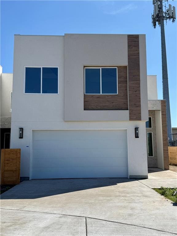 modern home with a garage, driveway, and stucco siding