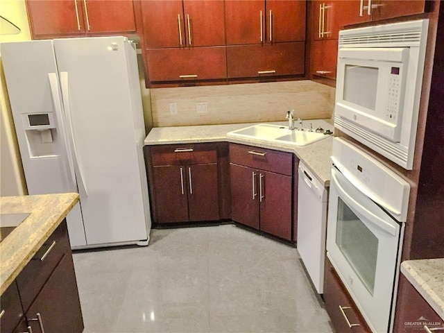 kitchen with decorative backsplash, sink, light tile patterned flooring, and white appliances