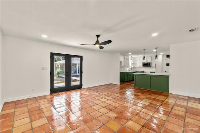 unfurnished living room with french doors, ceiling fan, light tile patterned flooring, and sink