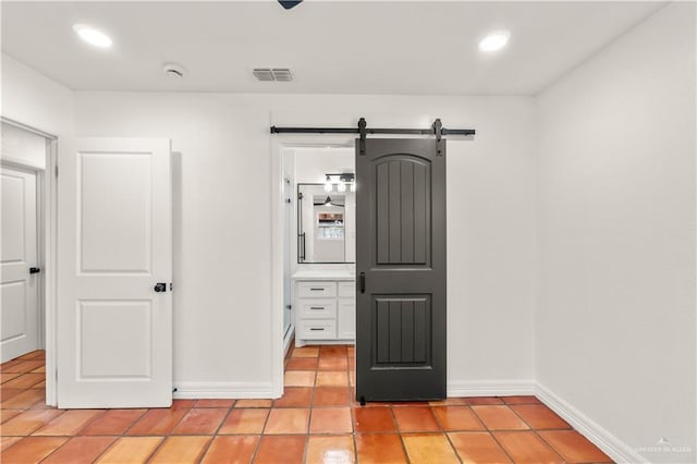 unfurnished bedroom featuring a barn door and light tile patterned flooring