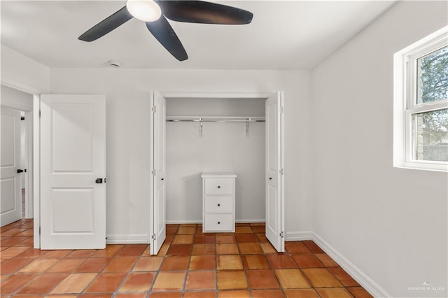 unfurnished bedroom with tile patterned flooring, a closet, and ceiling fan