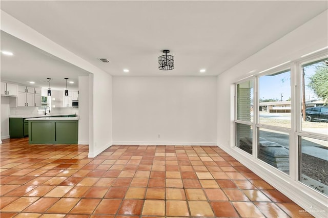 empty room featuring sink and light tile patterned floors