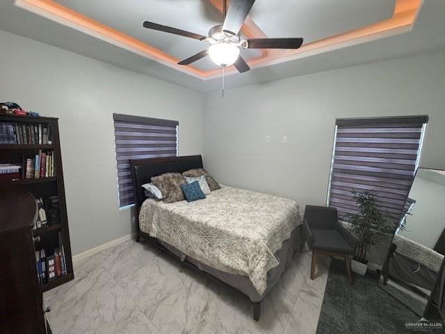 bedroom featuring a tray ceiling and ceiling fan