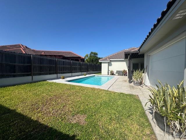 view of swimming pool featuring a lawn and a patio