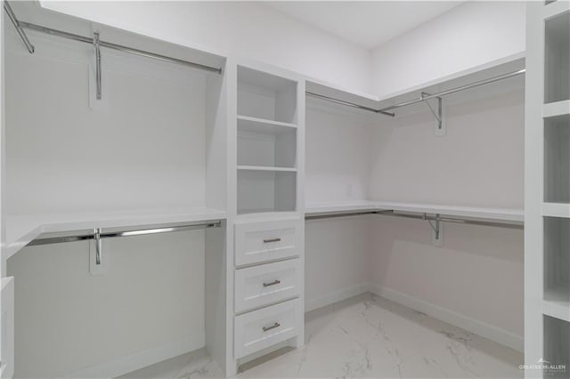 walk in closet featuring marble finish floor
