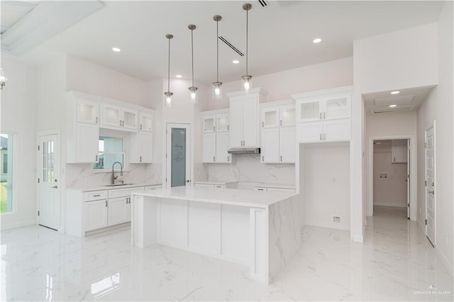 kitchen featuring white cabinets, recessed lighting, a kitchen island, and a wealth of natural light
