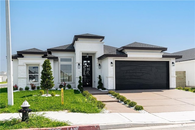prairie-style home featuring concrete driveway, stucco siding, a shingled roof, and a garage