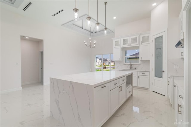 kitchen with white cabinetry, visible vents, an inviting chandelier, and marble finish floor