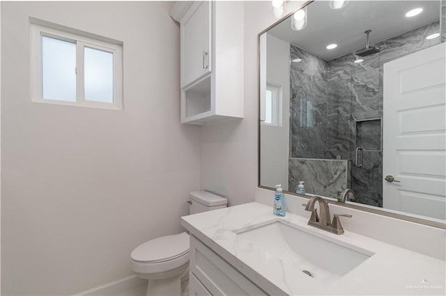 bathroom with baseboards, vanity, toilet, a marble finish shower, and recessed lighting