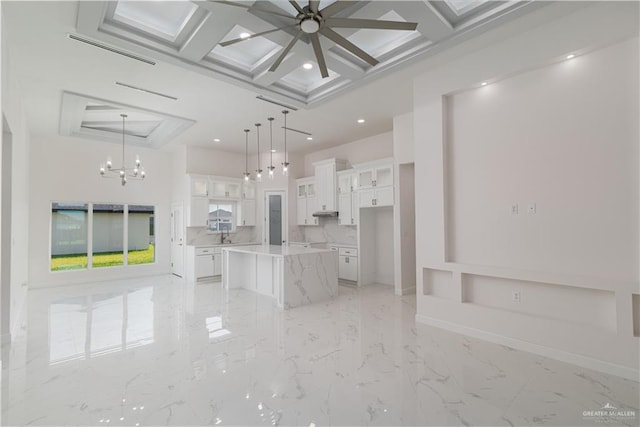 living area with ceiling fan with notable chandelier, marble finish floor, recessed lighting, beamed ceiling, and coffered ceiling