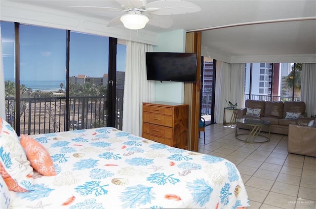 bedroom featuring multiple windows, light tile patterned floors, ceiling fan, and a wall of windows