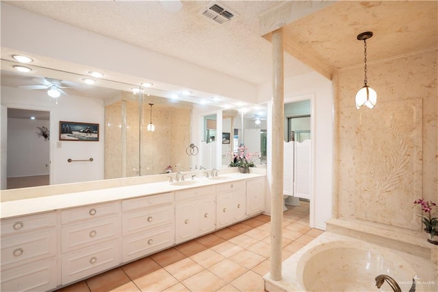 bathroom featuring double vanity, a ceiling fan, a garden tub, tile patterned flooring, and a textured ceiling