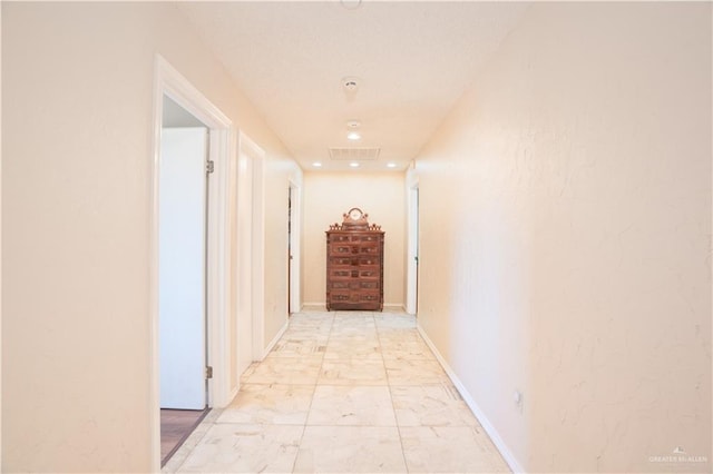 corridor featuring marble finish floor, visible vents, and baseboards