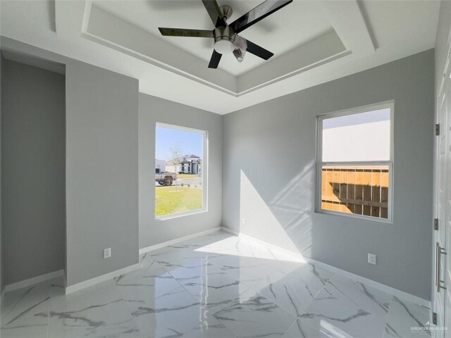 1313 W Dawes Ave W, Alton, TX 78573 - empty room featuring a tray ceiling, baseboards, ceiling fan, and marble finish floors