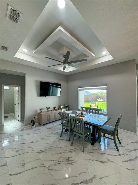 1313 W Dawes Ave W, Alton, TX 78573 - dining area with a raised ceiling, ceiling fan, recessed lighting, light marble finish floors, and baseboards