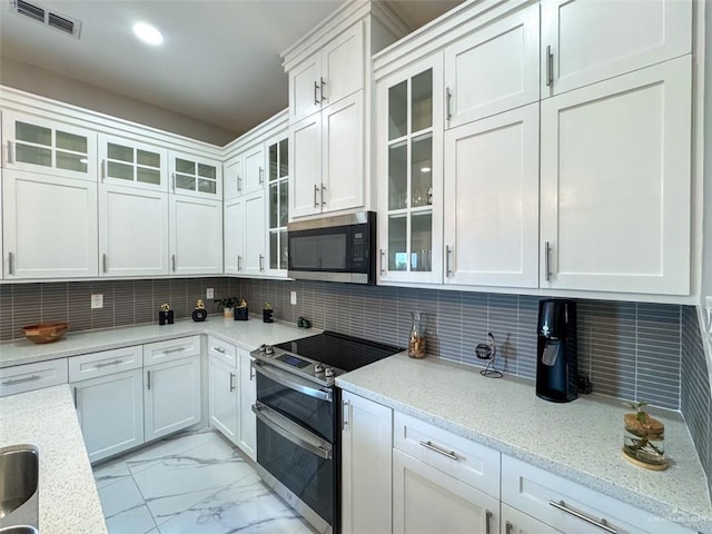 1313 W Dawes Ave W, Alton, TX 78573 - kitchen with appliances with stainless steel finishes, light marble finish floors, white cabinetry, glass insert cabinets, and tasteful backsplash