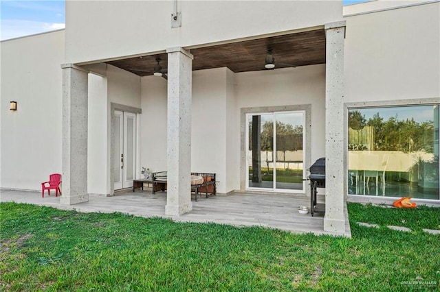 property entrance with a yard, a patio area, and ceiling fan