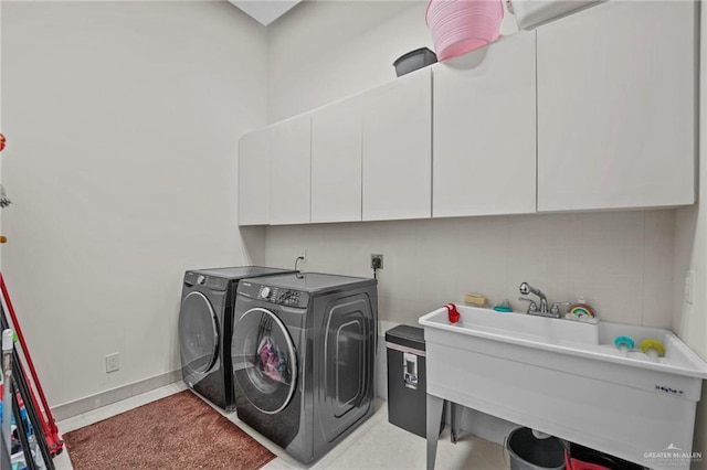 laundry room featuring cabinets, washing machine and clothes dryer, and sink