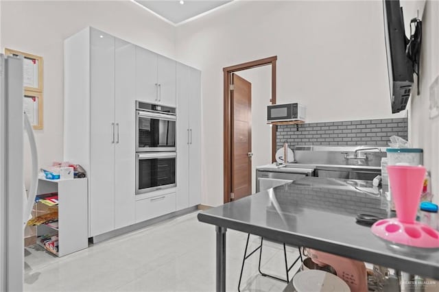 kitchen featuring white cabinetry, stainless steel double oven, refrigerator, and sink