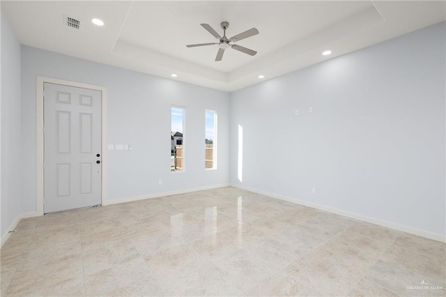 empty room with ceiling fan, recessed lighting, visible vents, baseboards, and a raised ceiling