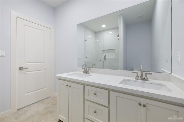 bathroom featuring a stall shower, visible vents, a sink, and double vanity