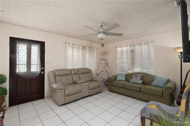 living room with light tile patterned floors, ceiling fan, and a textured ceiling