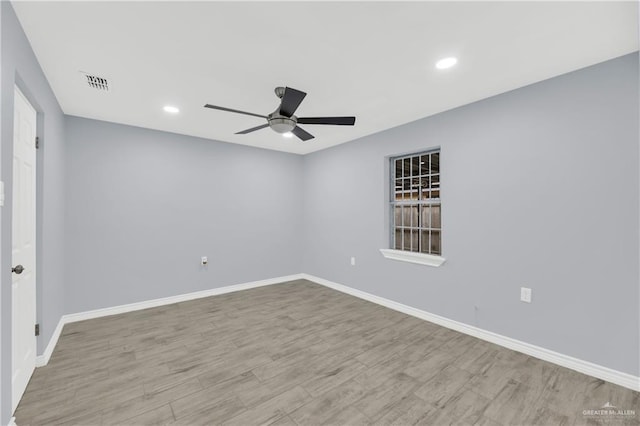 empty room with ceiling fan and light hardwood / wood-style floors