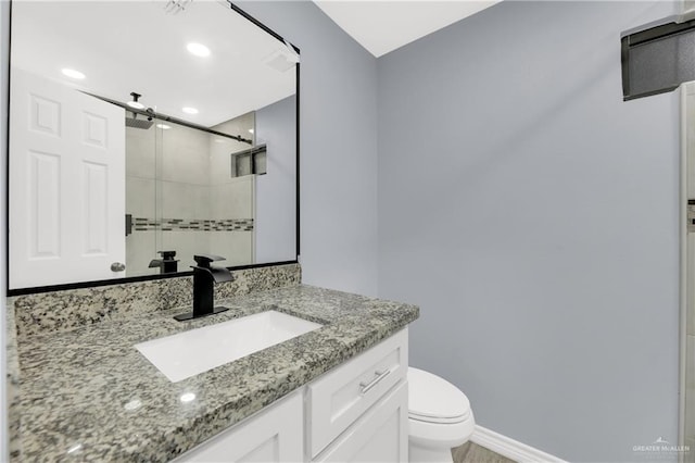 bathroom with vanity, toilet, and a shower with shower door