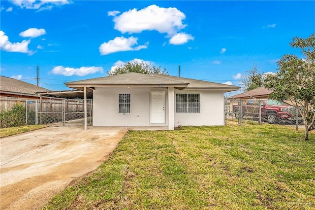 back of house with a carport and a yard