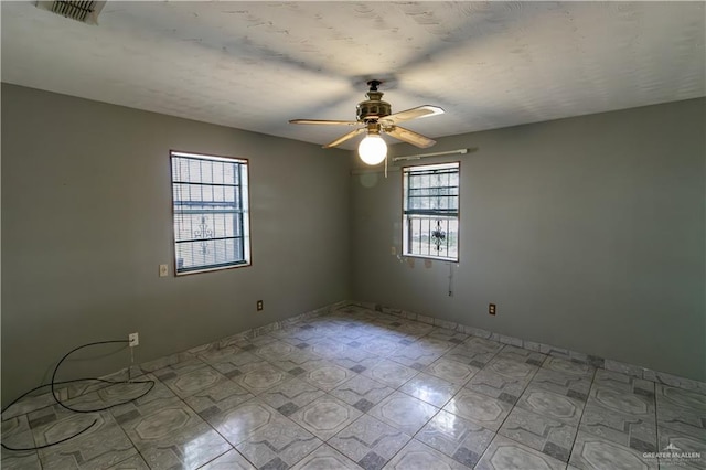 spare room featuring a ceiling fan and visible vents