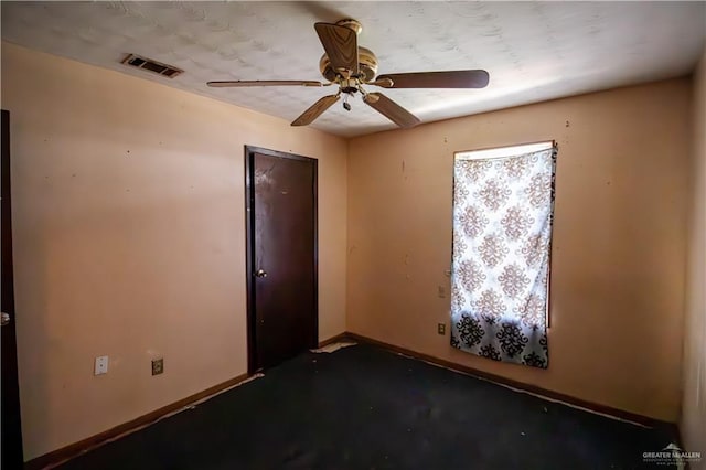 spare room with visible vents, ceiling fan, and baseboards