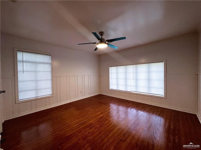 spare room featuring ceiling fan, dark wood-type flooring, and a wealth of natural light