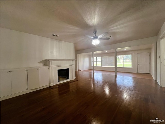 unfurnished living room featuring ceiling fan and dark wood-type flooring