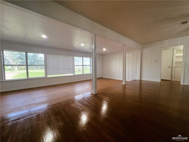 spare room featuring dark hardwood / wood-style flooring and plenty of natural light