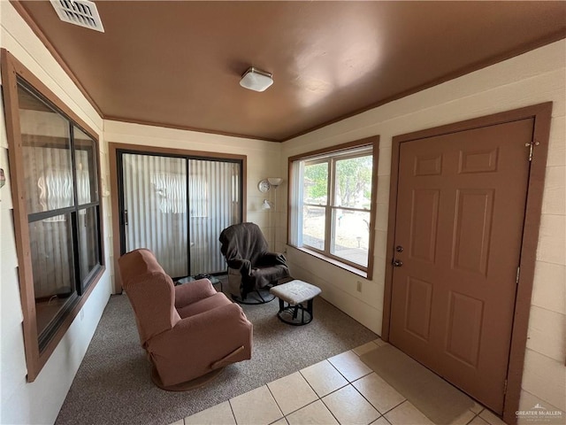 entrance foyer featuring light tile patterned flooring, visible vents, and light colored carpet