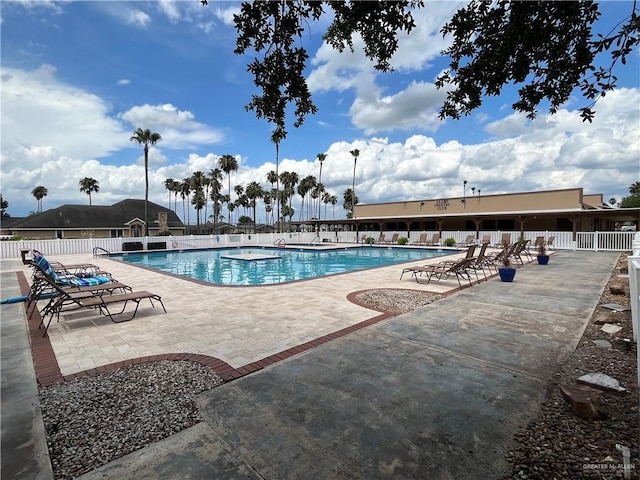 pool with a patio and fence